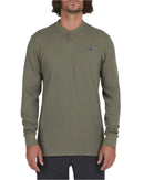 A man wearing an olive green long-sleeve crewneck Salty Crew thermal top.